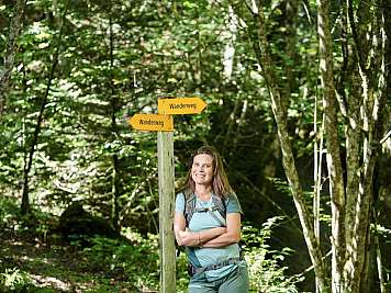 Frau am Wanderweg-Schild