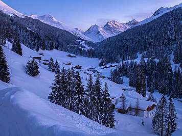 Verschneites Bergtal mit Häusern