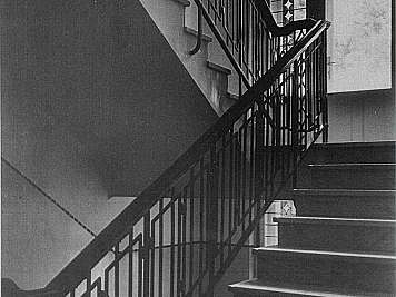 Black and white interior staircase with decorative iron railings