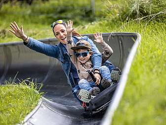 Mother and child on summer toboggan run