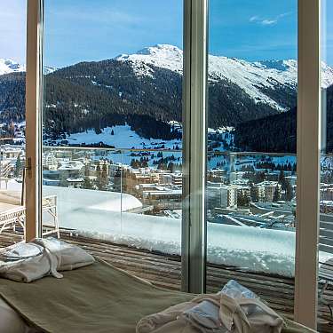 Schlafzimmer mit Terrasse und Blick auf verschneite Berge und ein Tal